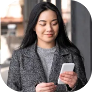 Female Deriv affiliate using mobile phone to monitor partnership earnings