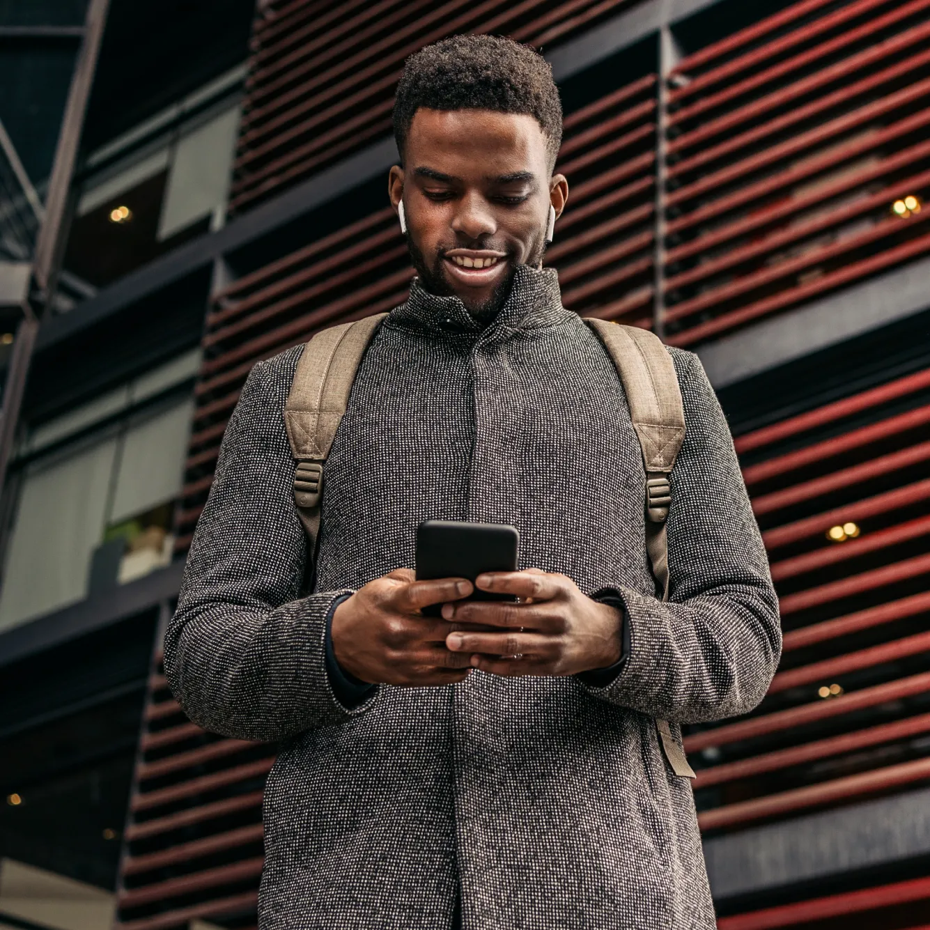 A trader using his mobile to trade crash boom indices on Deriv